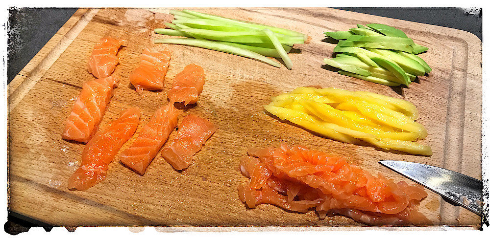 Zugeschnittene Zutaten fr mein erstes Sushi: Frischer Lachs, Salatgurke, Mango und Avocado